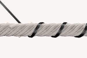 A thick, white rope is tightly coiled with black wire against a plain background, showcasing detailed texture.