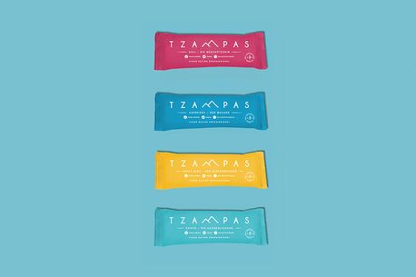 Vier bunte TZAMPAS-Riegel sind auf einem blauen Hintergrund vertikal angeordnet.