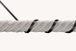 A thick, white rope is tightly coiled with black wire against a plain background, showcasing detailed texture.