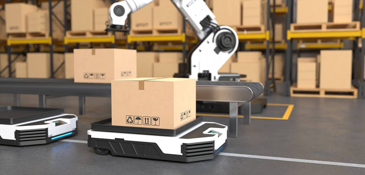 A robotic arm autonomously lifts a cardboard box in a warehouse setting with shelves full of packages.
