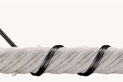 A thick white rope is tightly wrapped with a glossy black wire in a detailed close-up view.